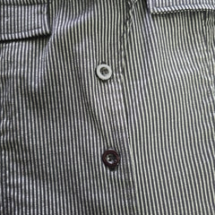 Close-up of a striped shirt with buttons on a plain background