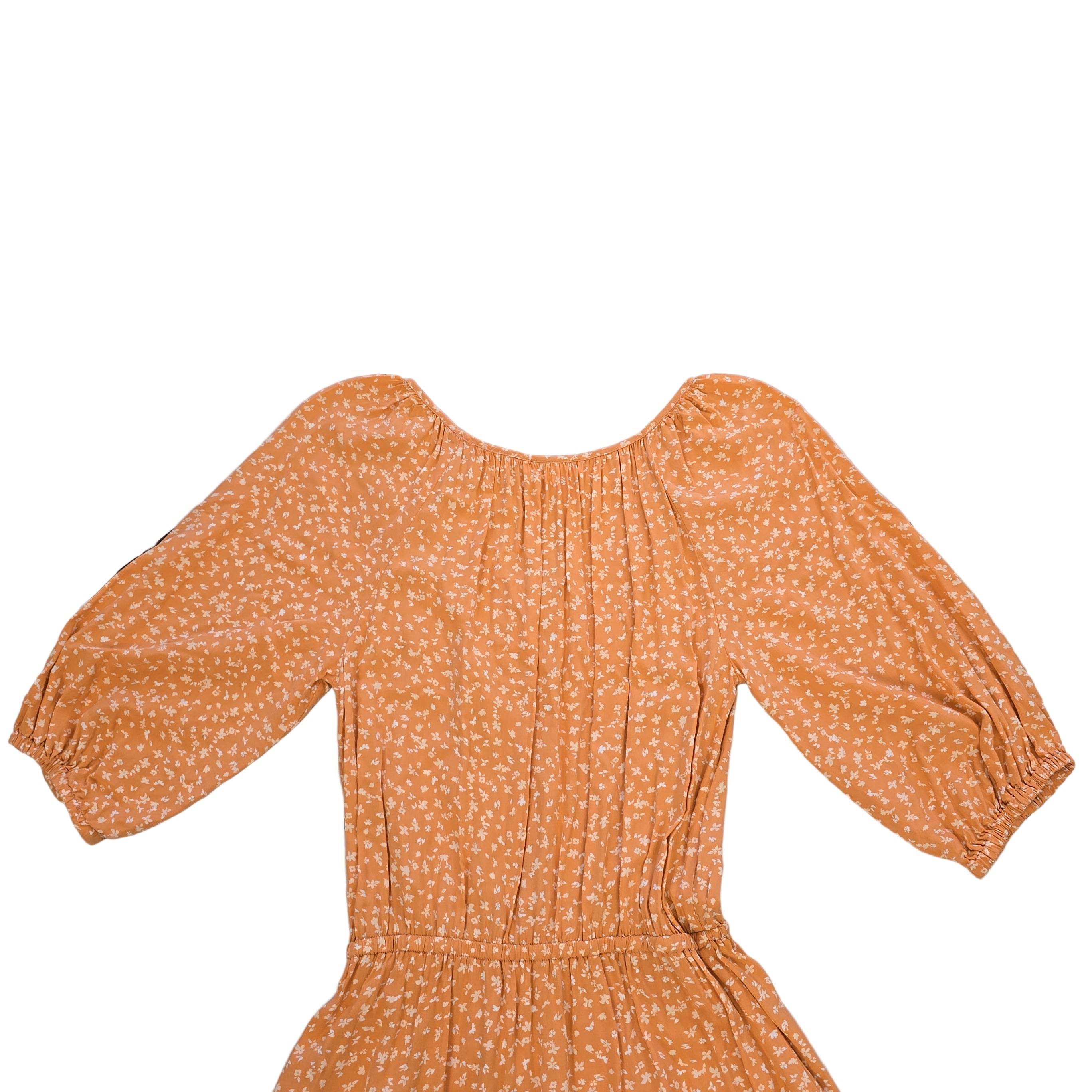 Orange floral dress on a tiled floor