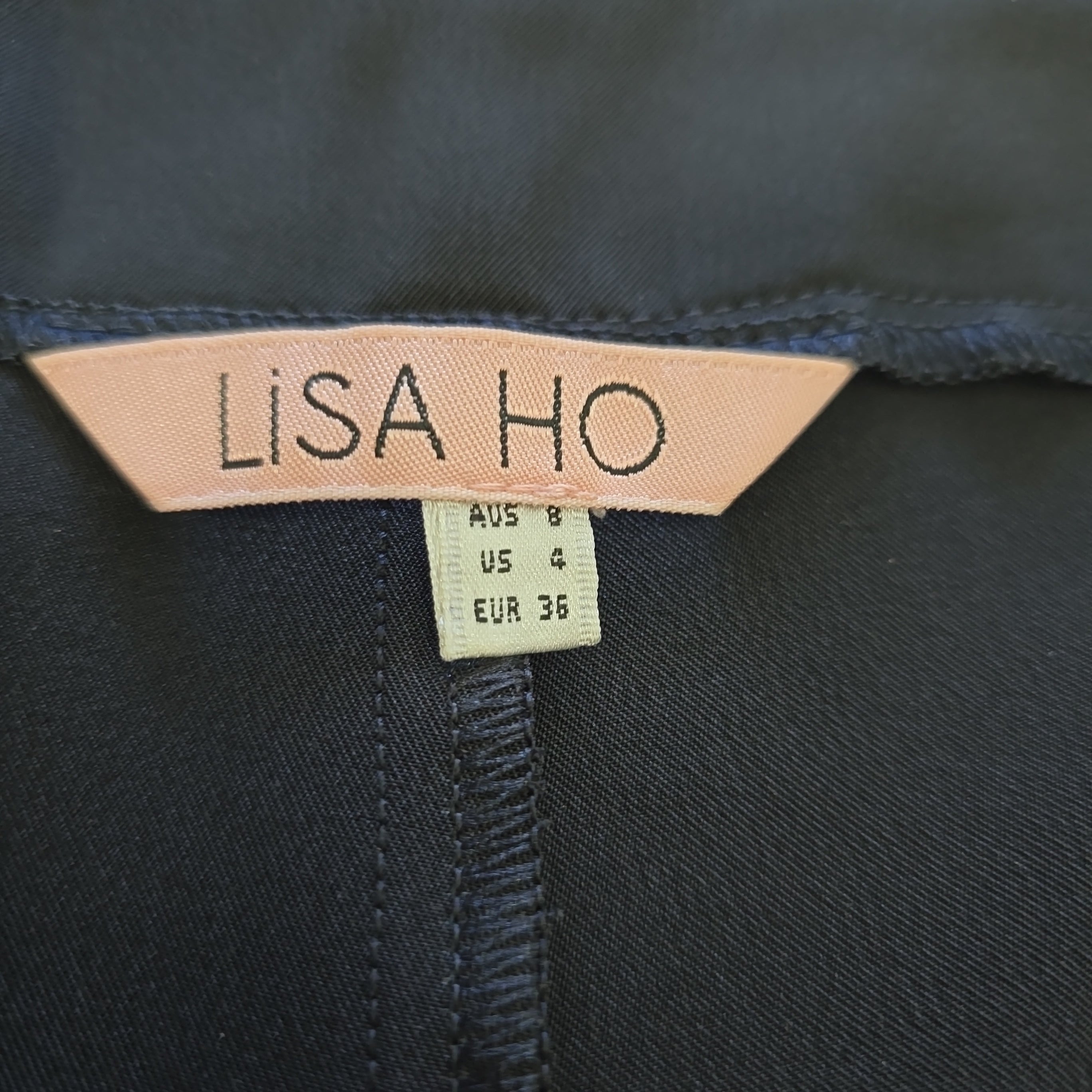 Close-up of a 'LISA HO' label on dark fabric