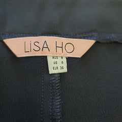 Close-up of a 'LISA HO' label on dark fabric