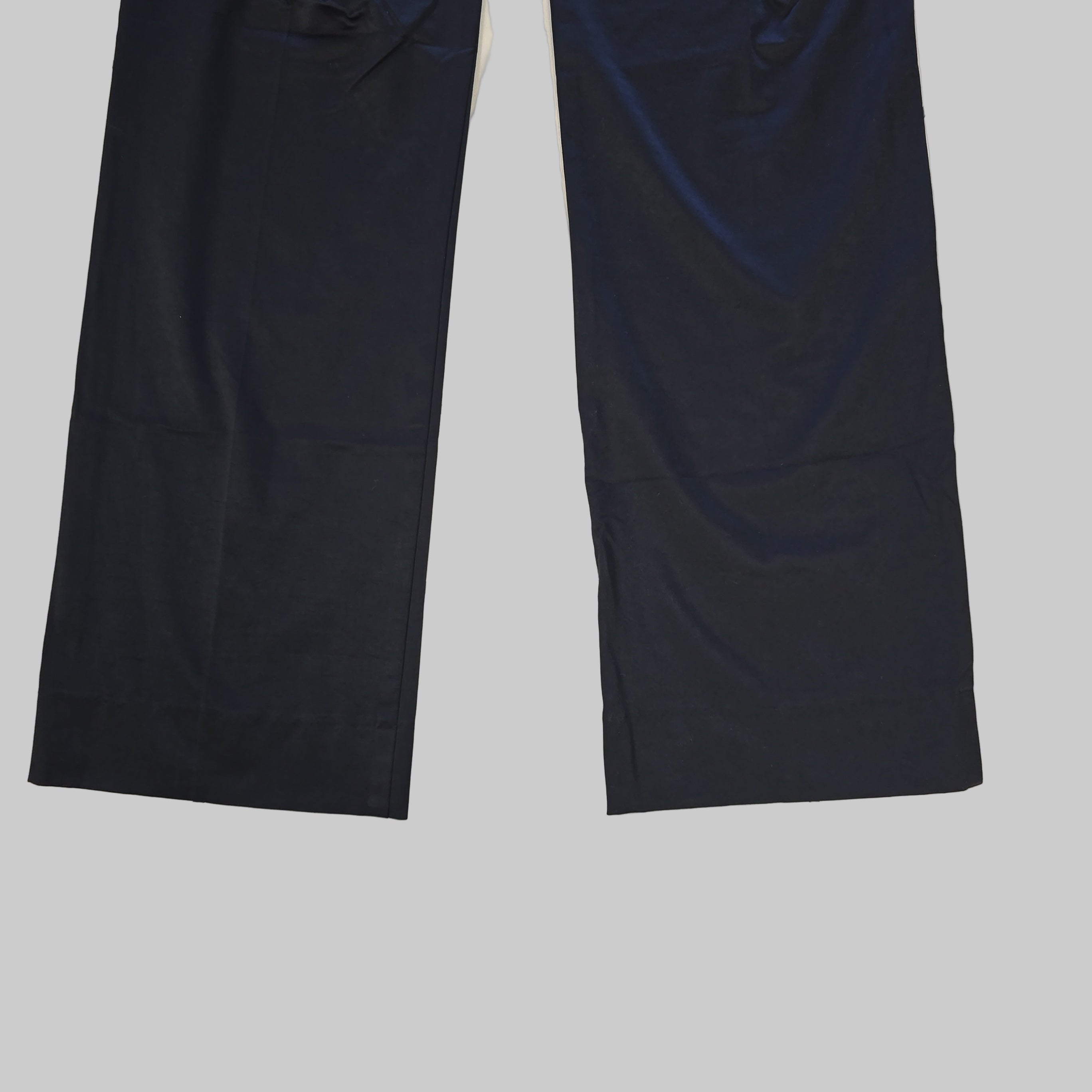 Two black pant legs laid flat on a tiled floor.