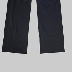 Two black pant legs laid flat on a tiled floor.