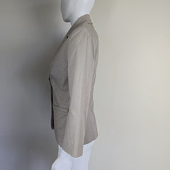 Mannequin wearing a light gray suit jacket on a plain background