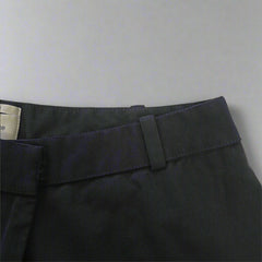Close-up of a black Pants with a strap on a beige background