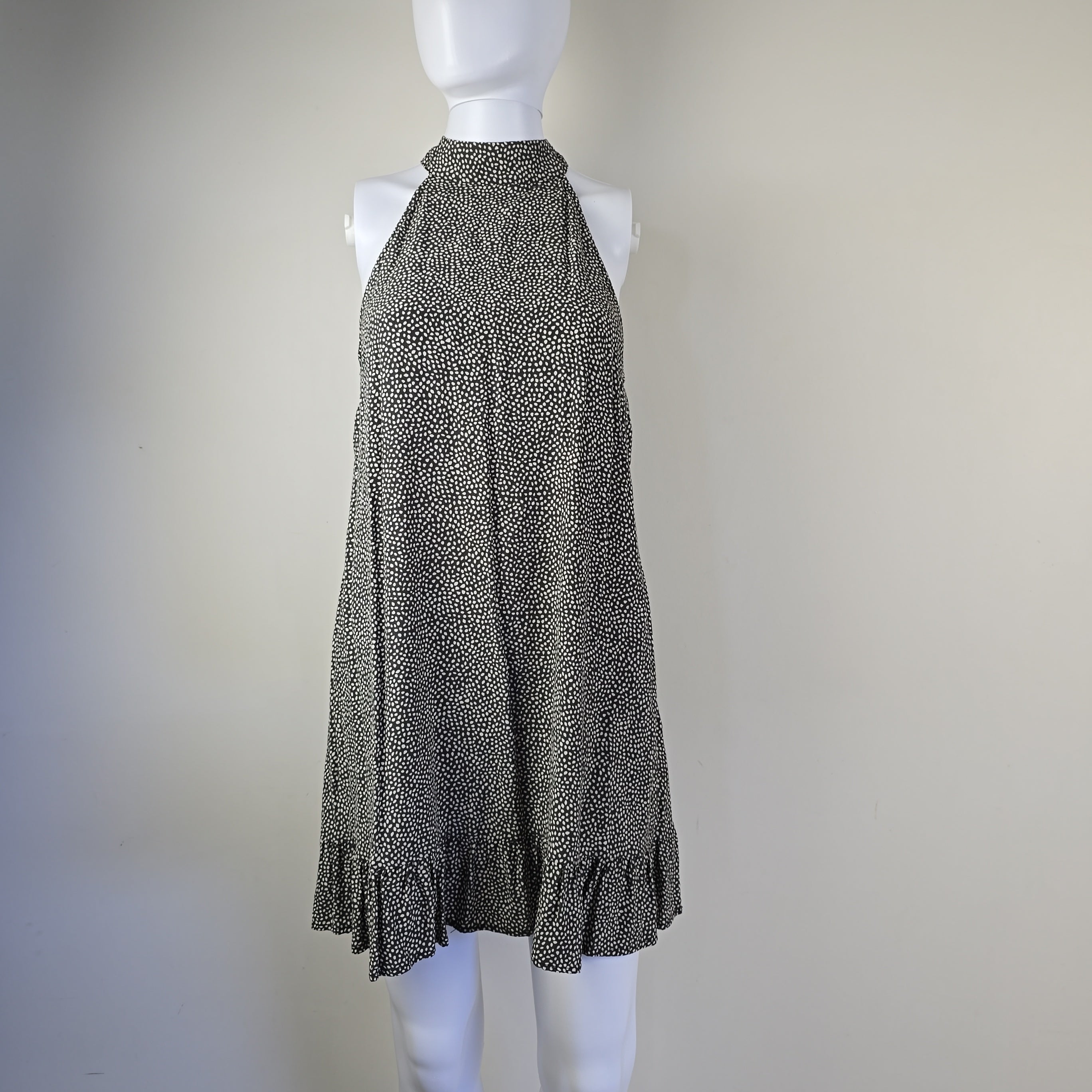 Grey and white spotted patterned dress on a light background