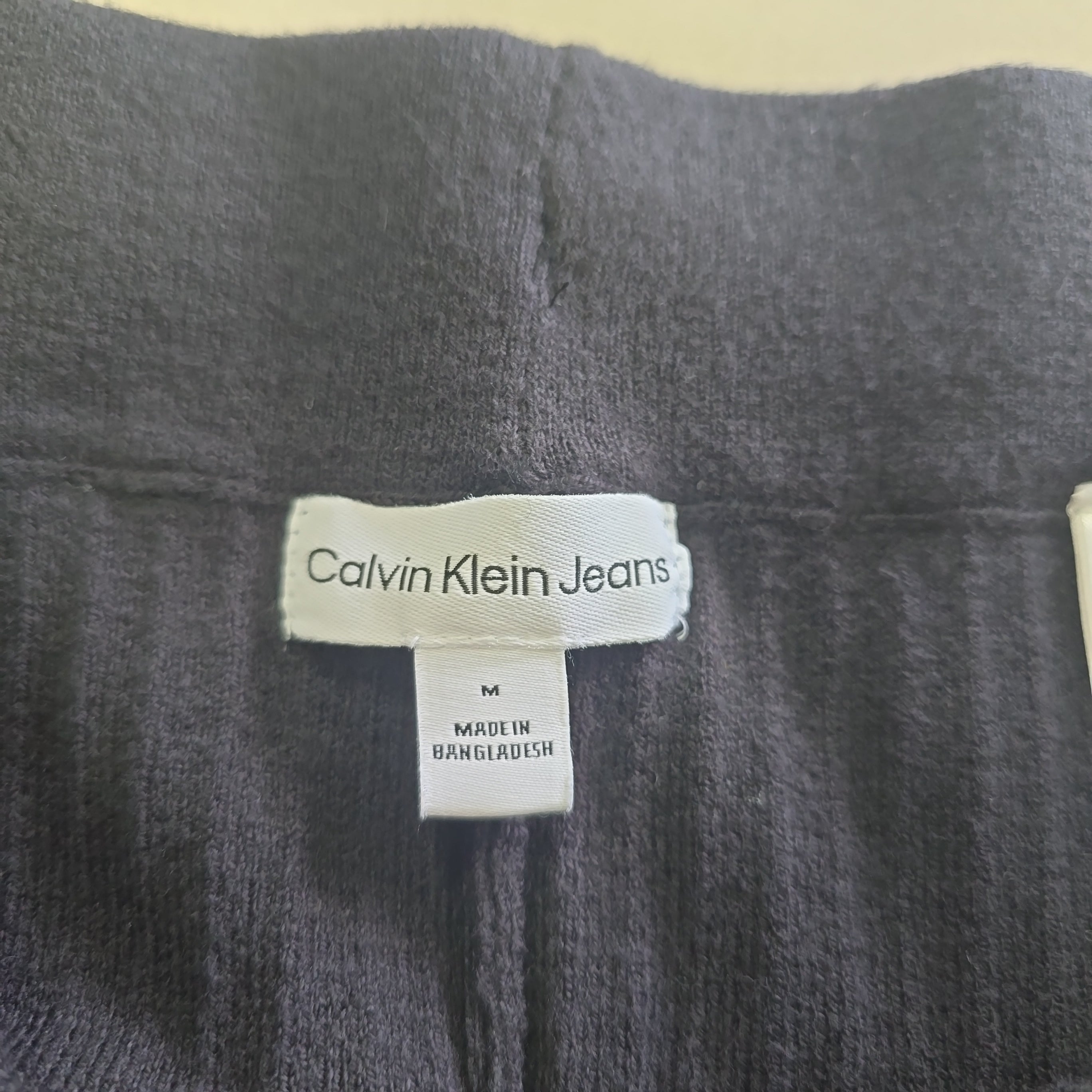Close-up of a Calvin Klein jeans label on a dark fabric background