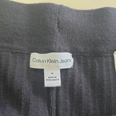 Close-up of a Calvin Klein jeans label on a dark fabric background