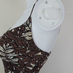 Close-up of a brown and beige patterned dress on a light gray background