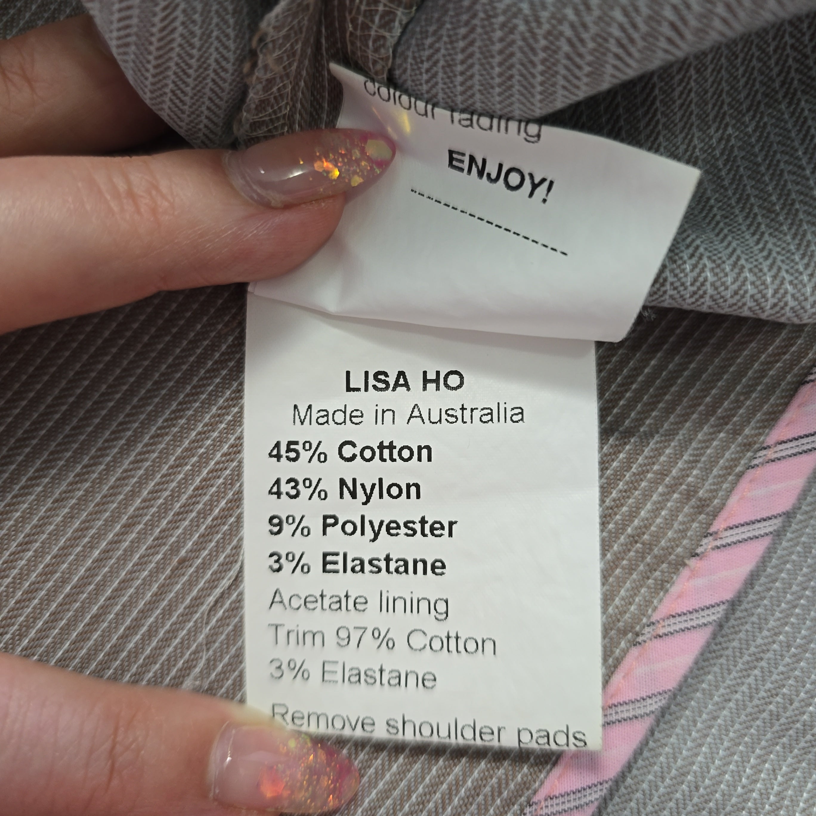 Fabric label with 'Lisa Ho' details on a textured fabric background