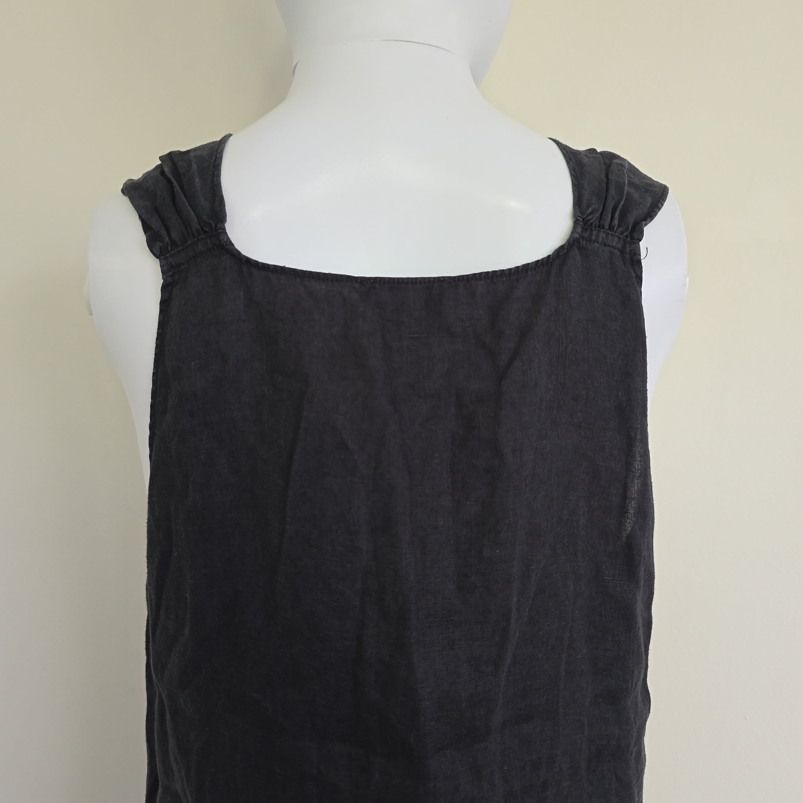 Black top on a mannequin against a beige background