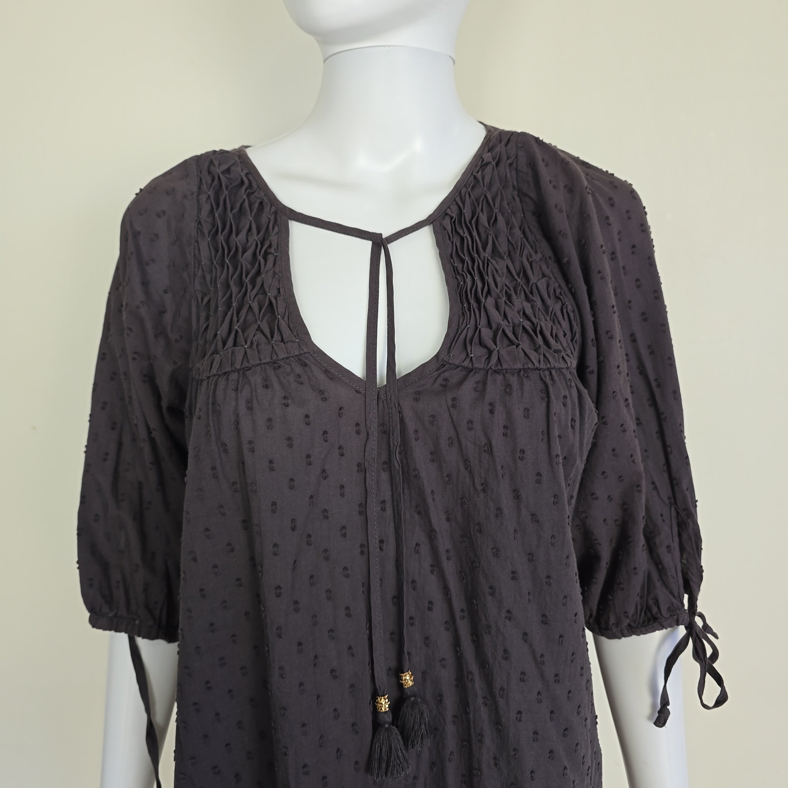 Brown textured top on a mannequin against a beige background