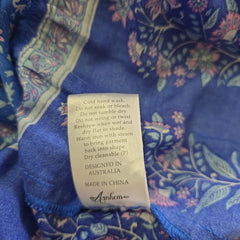 Clothing label on a blue fabric with floral patterns