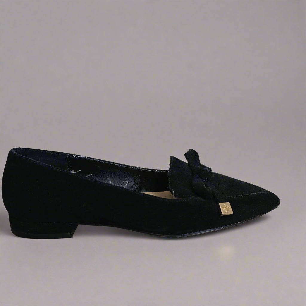 Black shoe with a bow on a tiled floor