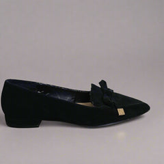 Black shoe with a bow on a tiled floor