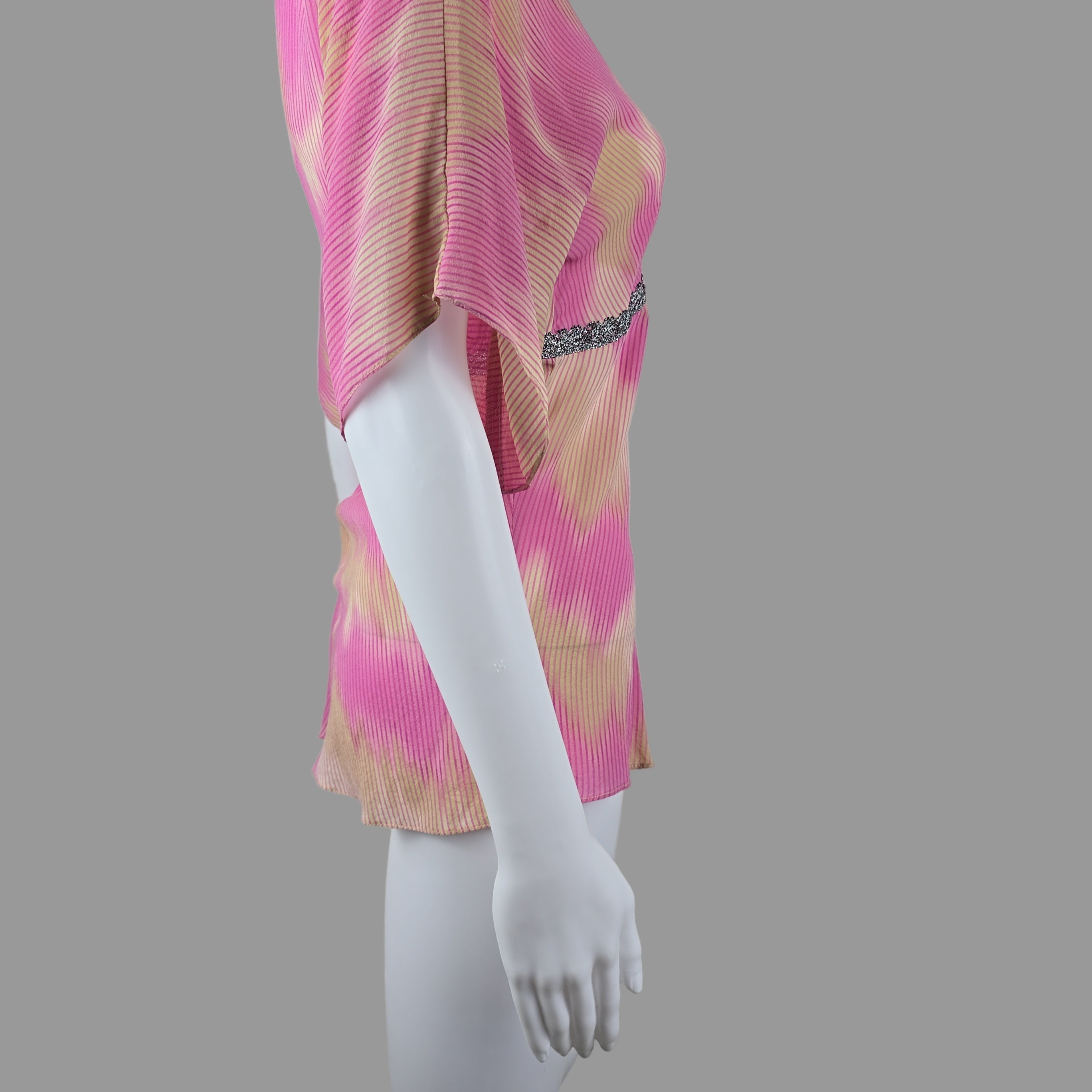 Mannequin with a pink and yellow patterned fabric on a plain background