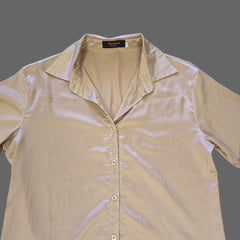 Beige shirt with a brand label on a tiled floor