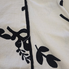 Close-up of a white fabric with black leaf patterns