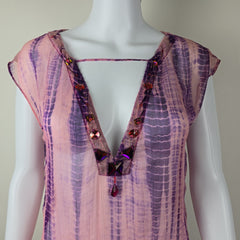 Mannequin wearing a pink and purple patterned dress with embellishments on a plain background