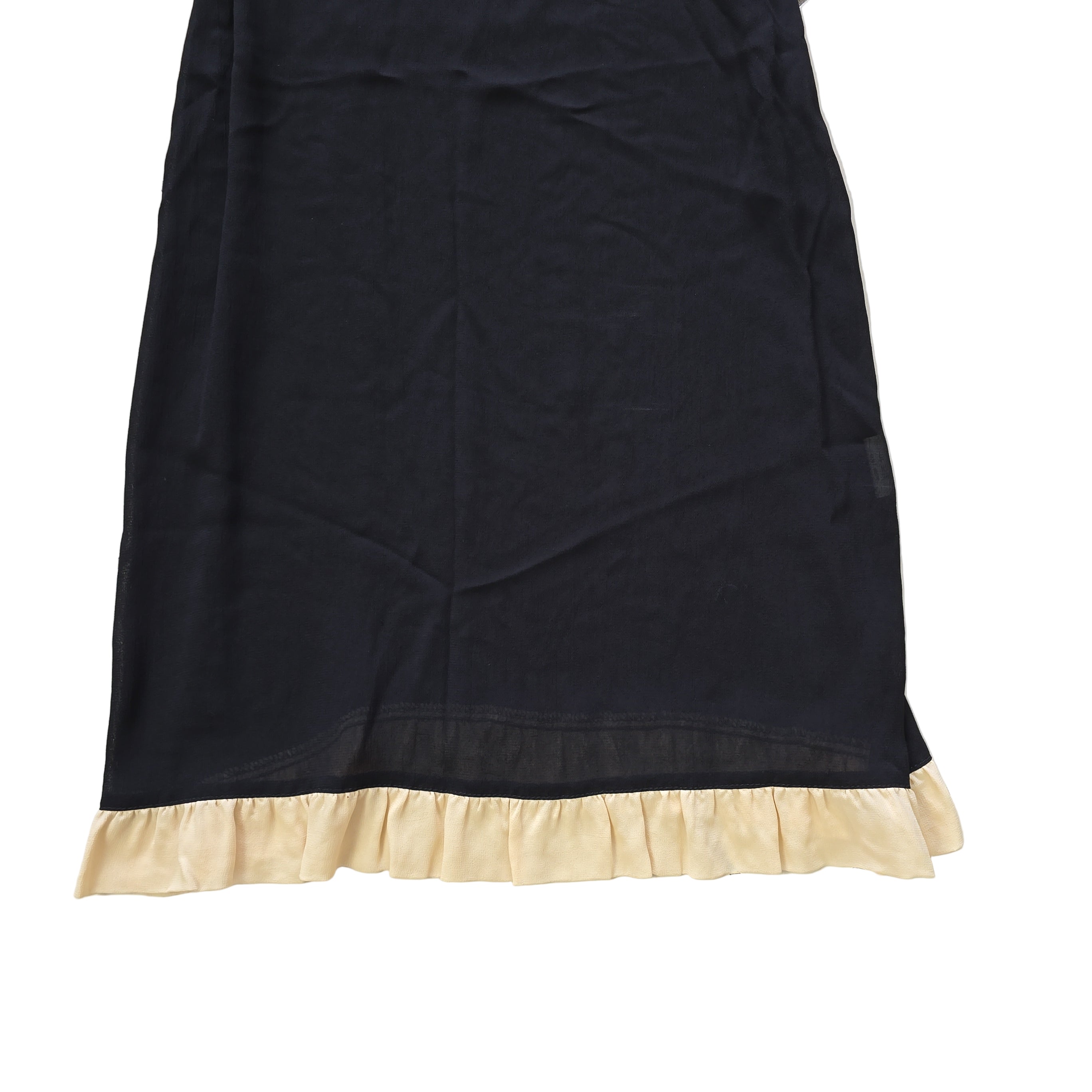 Black dress with beige lining on a light floor