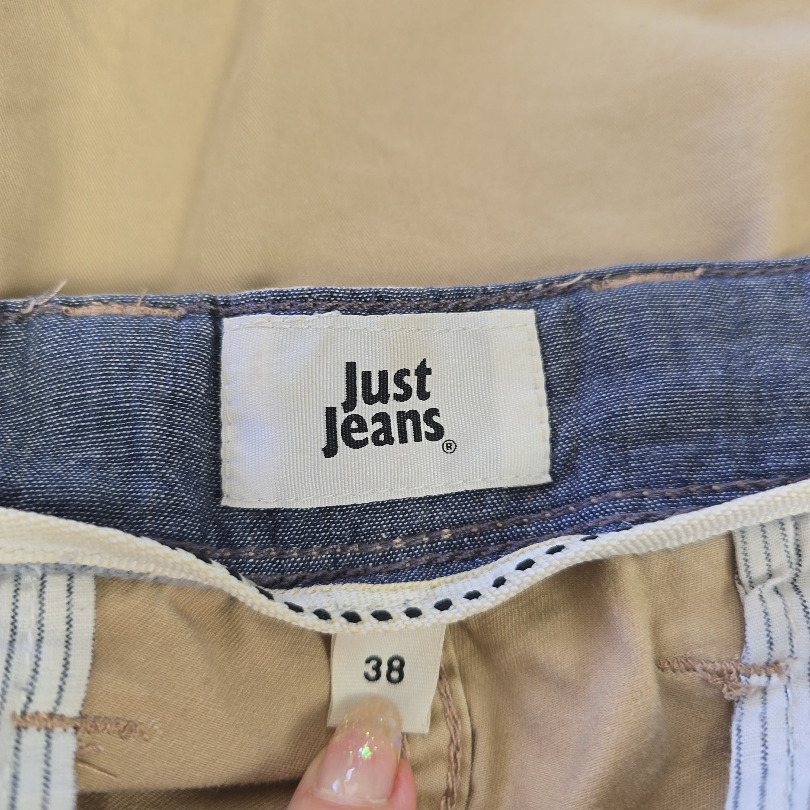 Close-up of 'Just Jeans' label on a denim garment with a visible size tag.