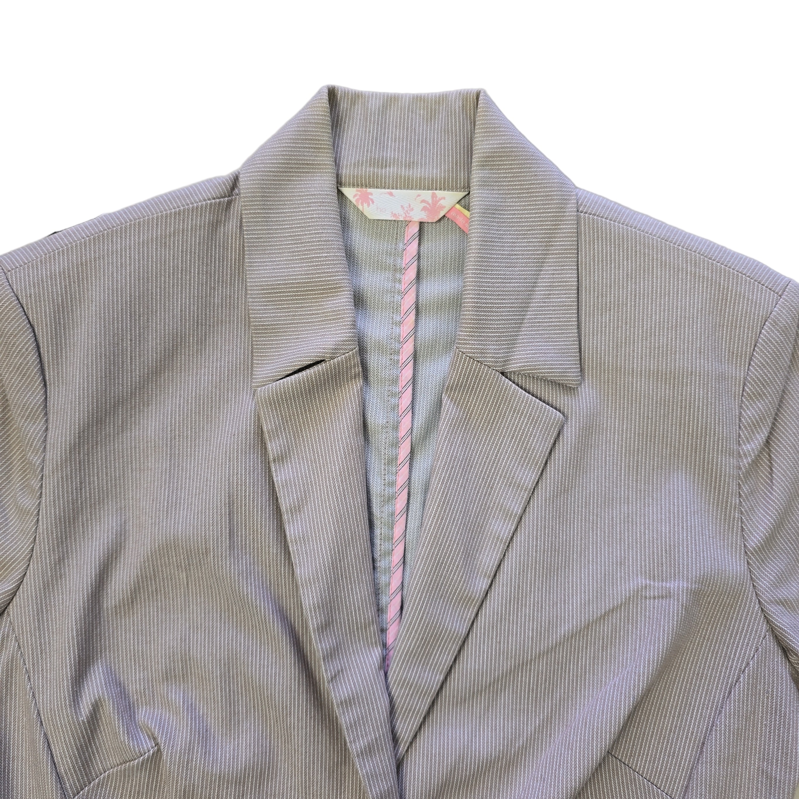 Brown jacket with pink and white striped trim on a light surface