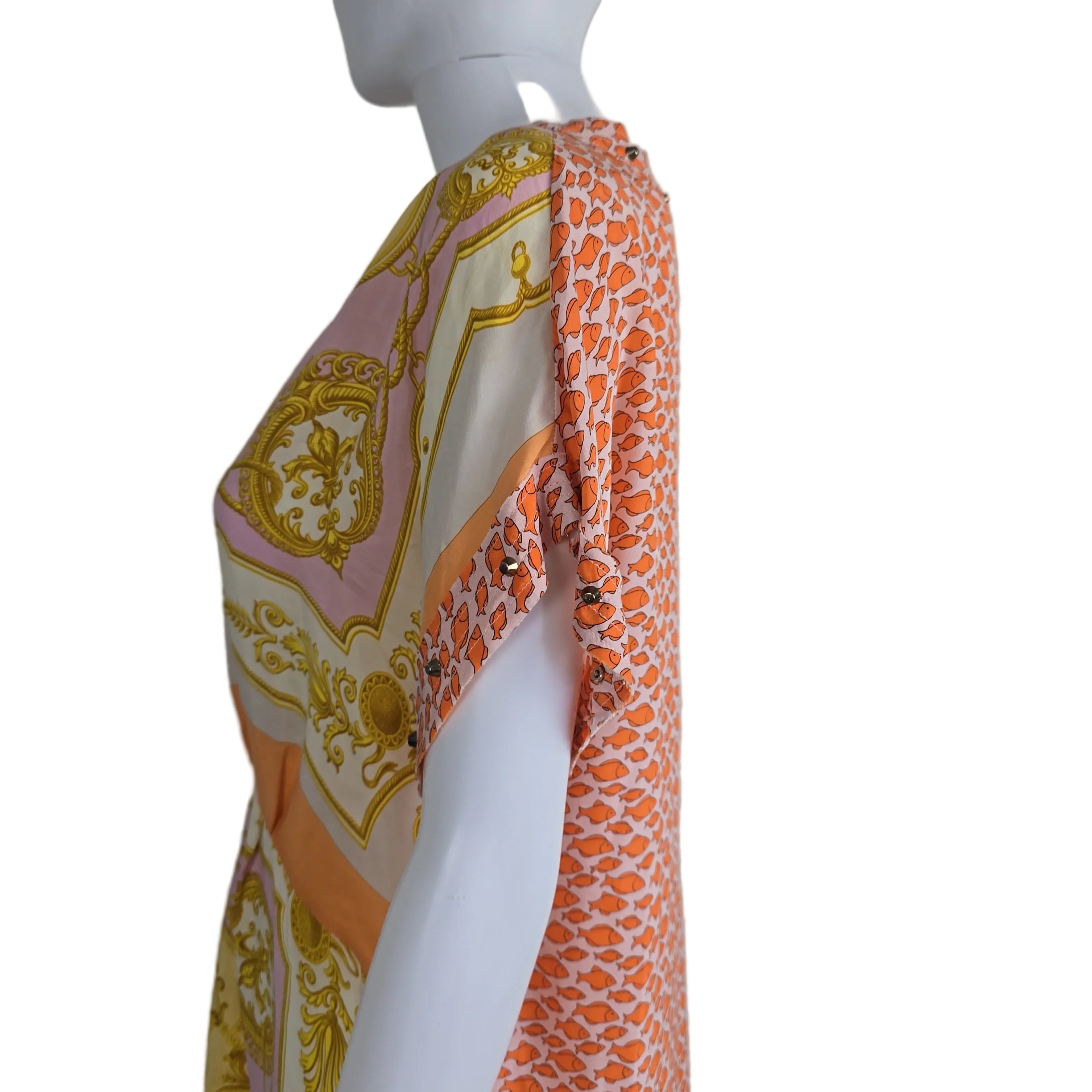 Fabric with orange and pink pattern on a mannequin against a plain background