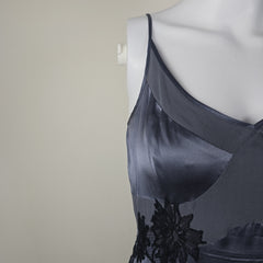 Gray lace bra on a mannequin against a plain background