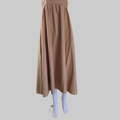 Brown skirt hanging on a white door handle against a tiled wall.