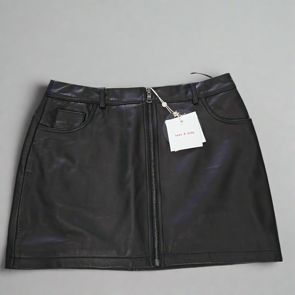 Black leather skirt with a tag on a tiled floor