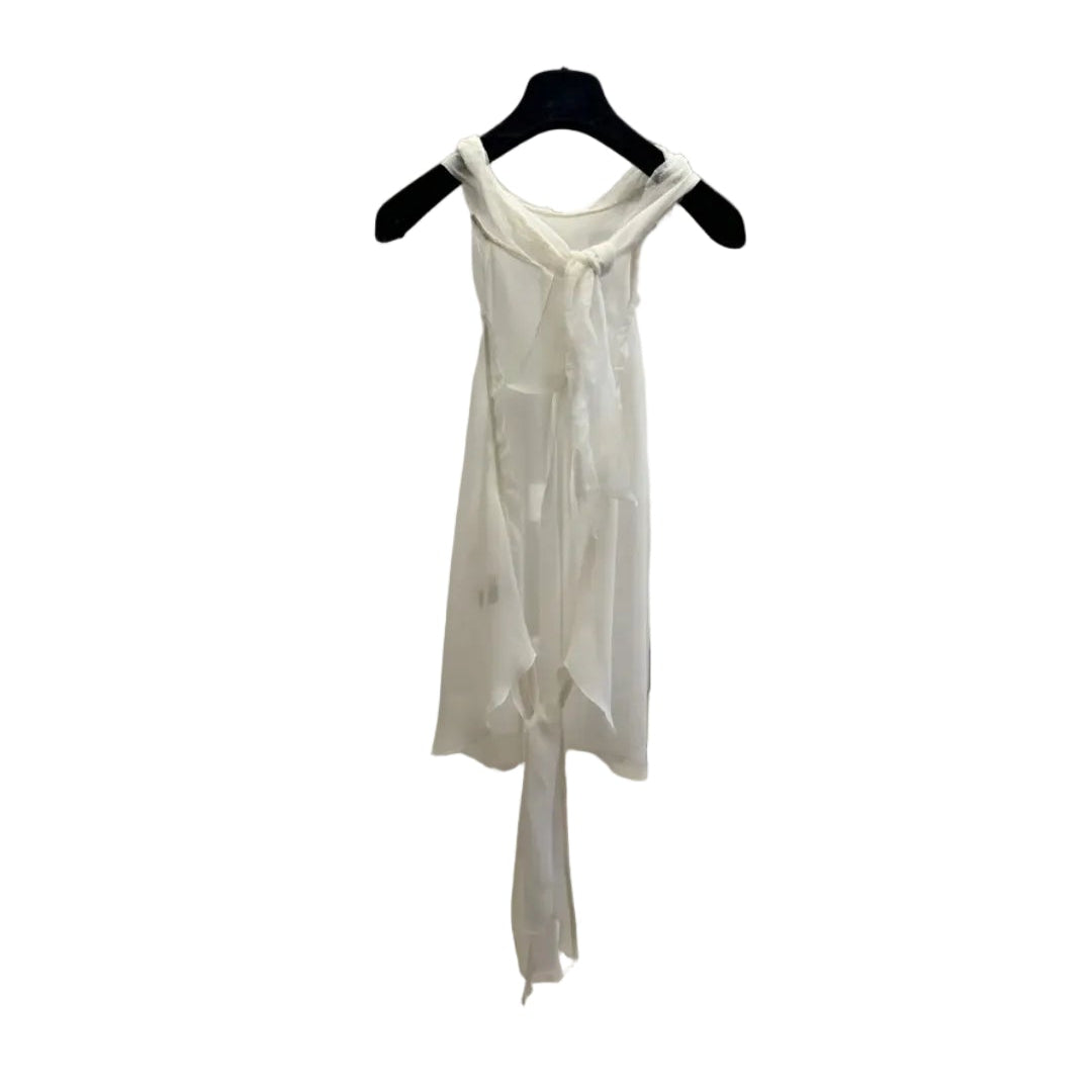 White sheer top on a hanger against a neutral wall.