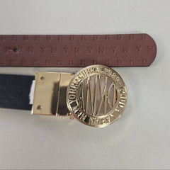 Gold belt buckle with engraved design on a gray background