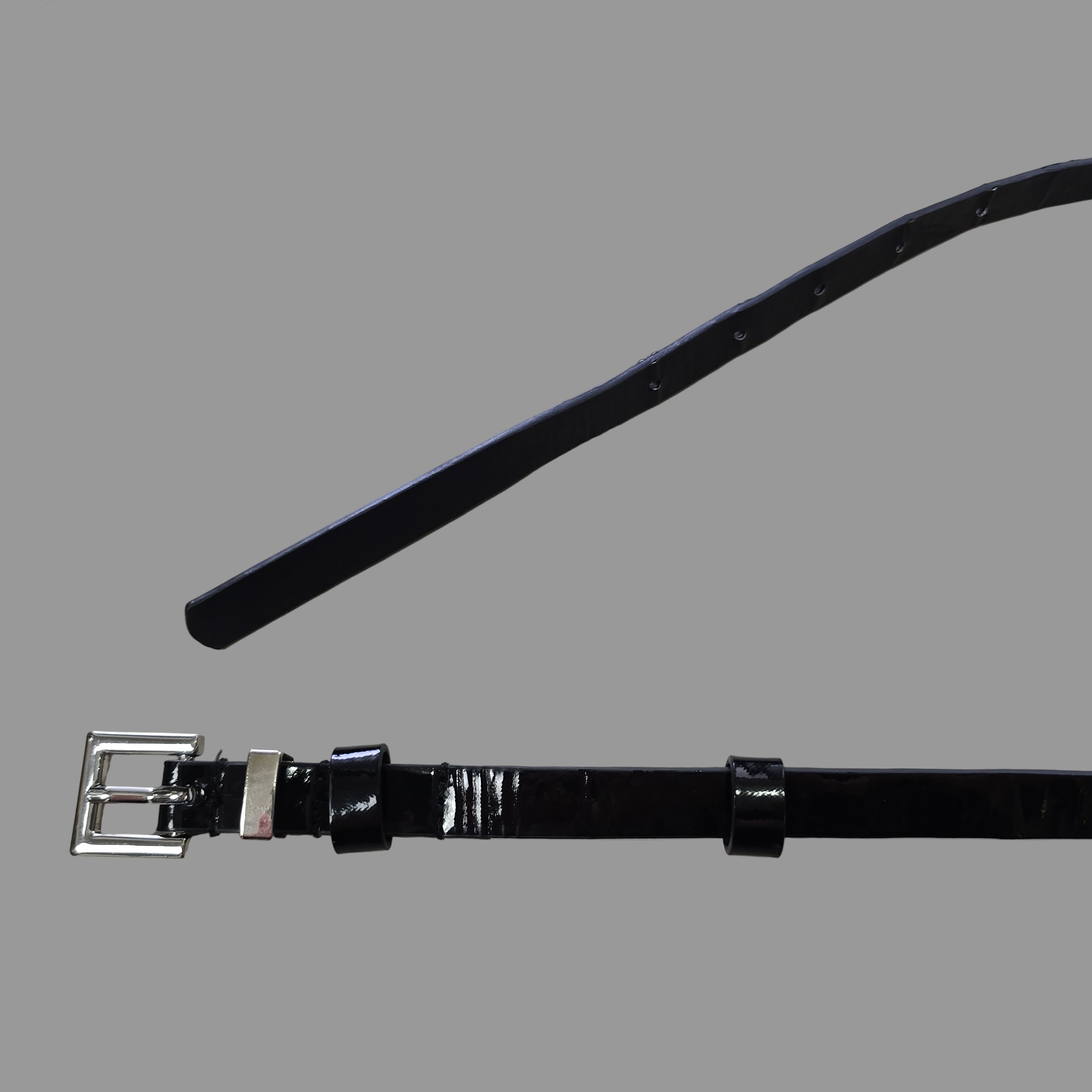 Black leather belt with silver buckle on a light gray background