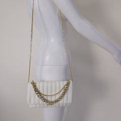 Gold chain bag on a white mannequin bust with a plain background