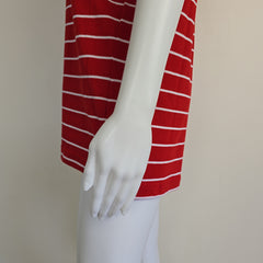 Mannequin arm wearing a red and white striped garment against a plain background