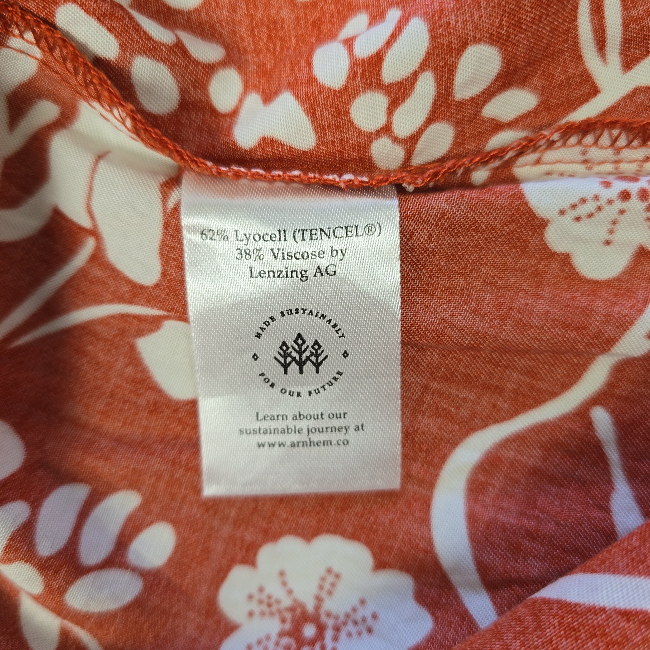 Fabric with a floral pattern and a visible label on an orange background