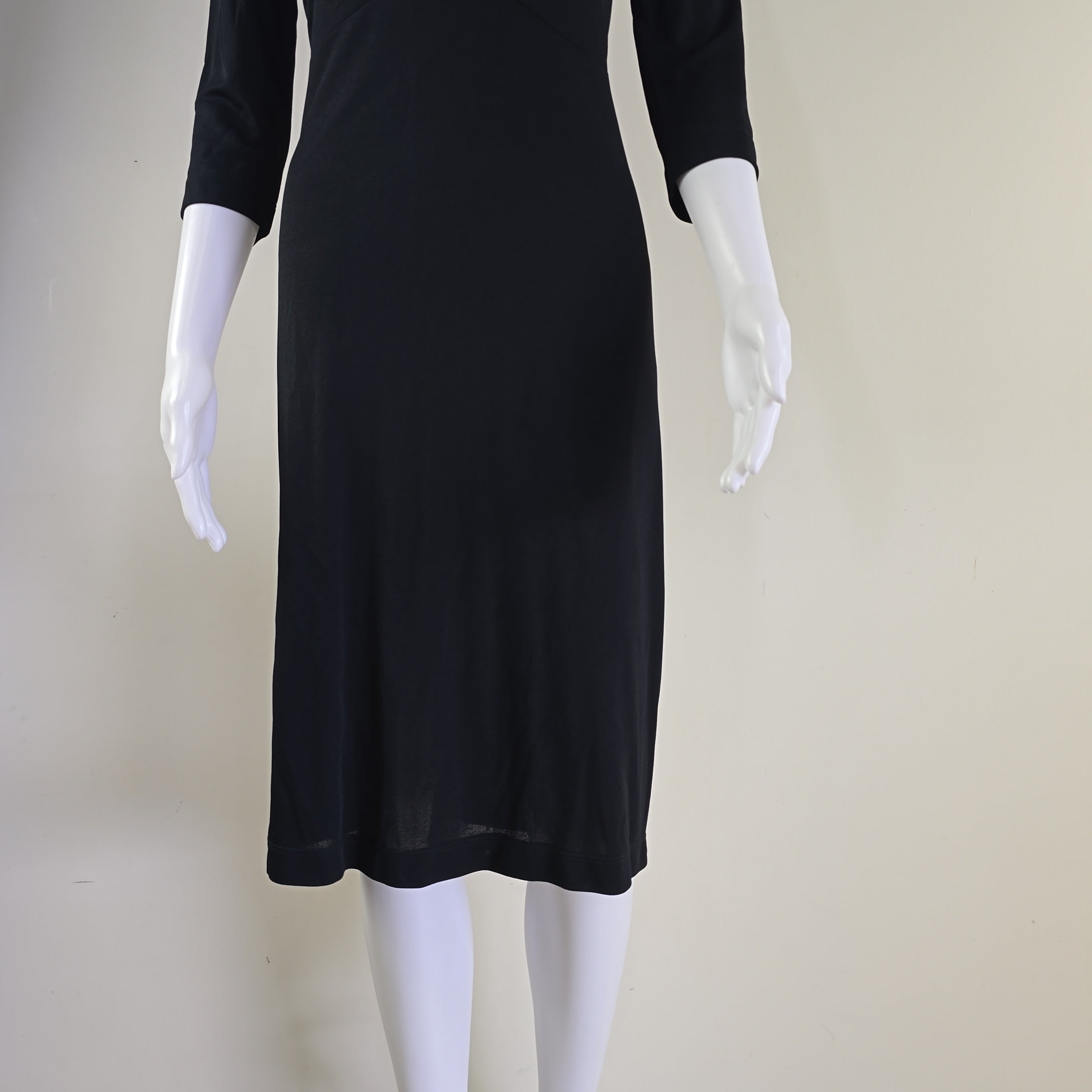 Black dress on a white mannequin against a beige background