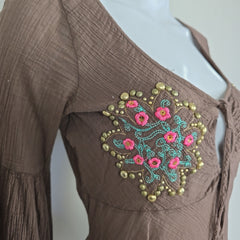 Brown fabric with floral embroidery on a mannequin