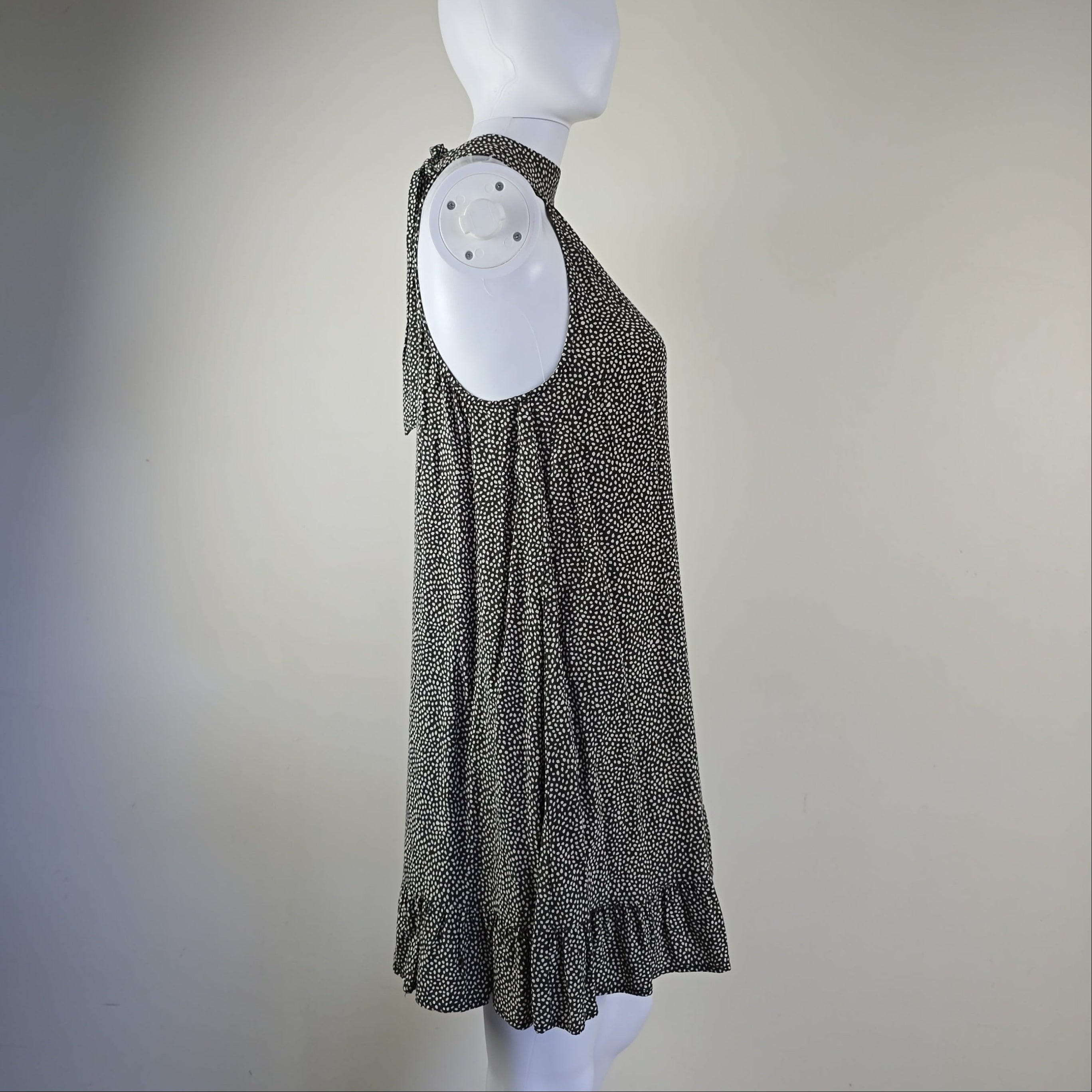 Grey and white spotted patterned dress on a light background