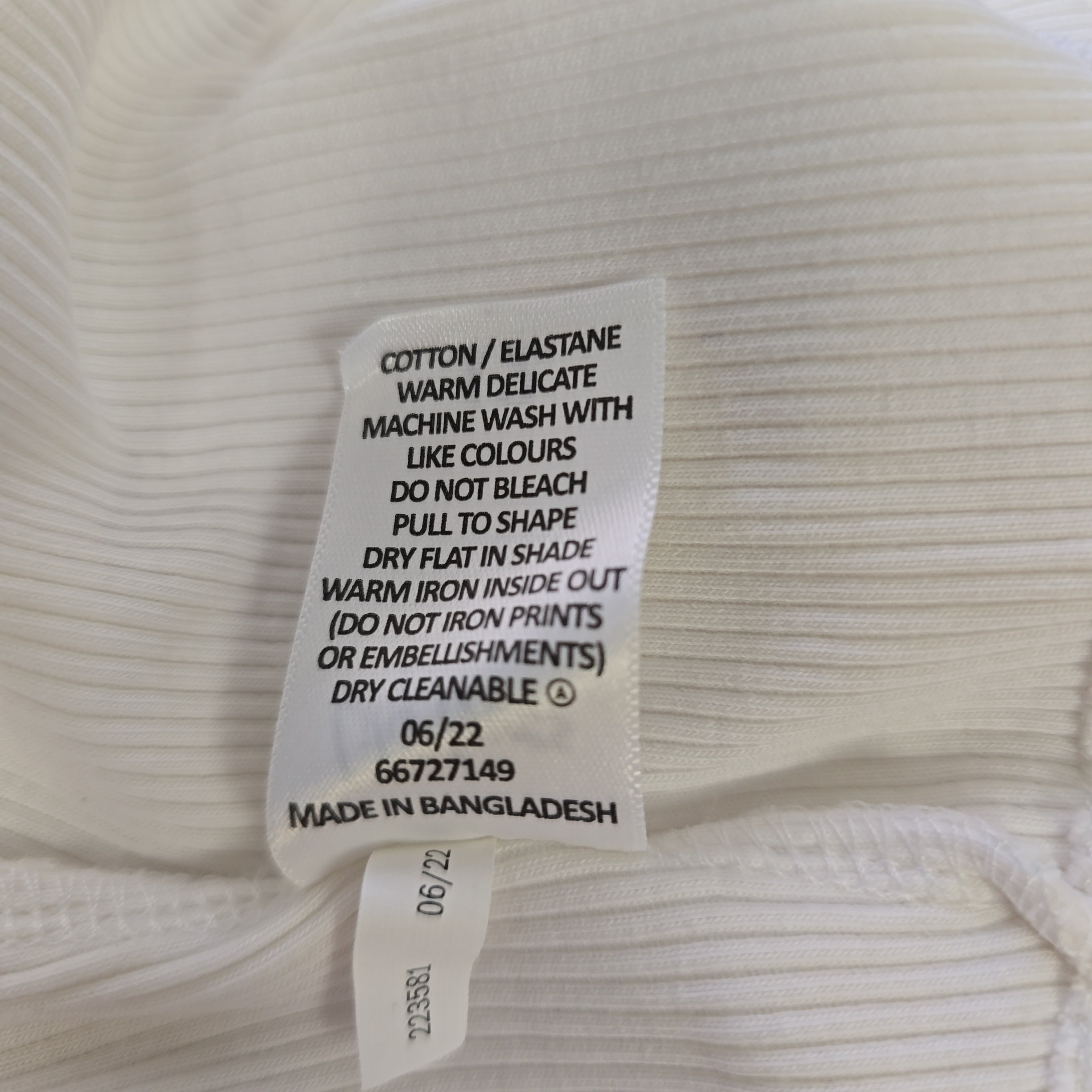 Clothing label on a white ribbed fabric background