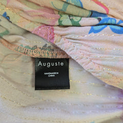 Close-up of a fabric with a 'Auguste' label on a multicolored background