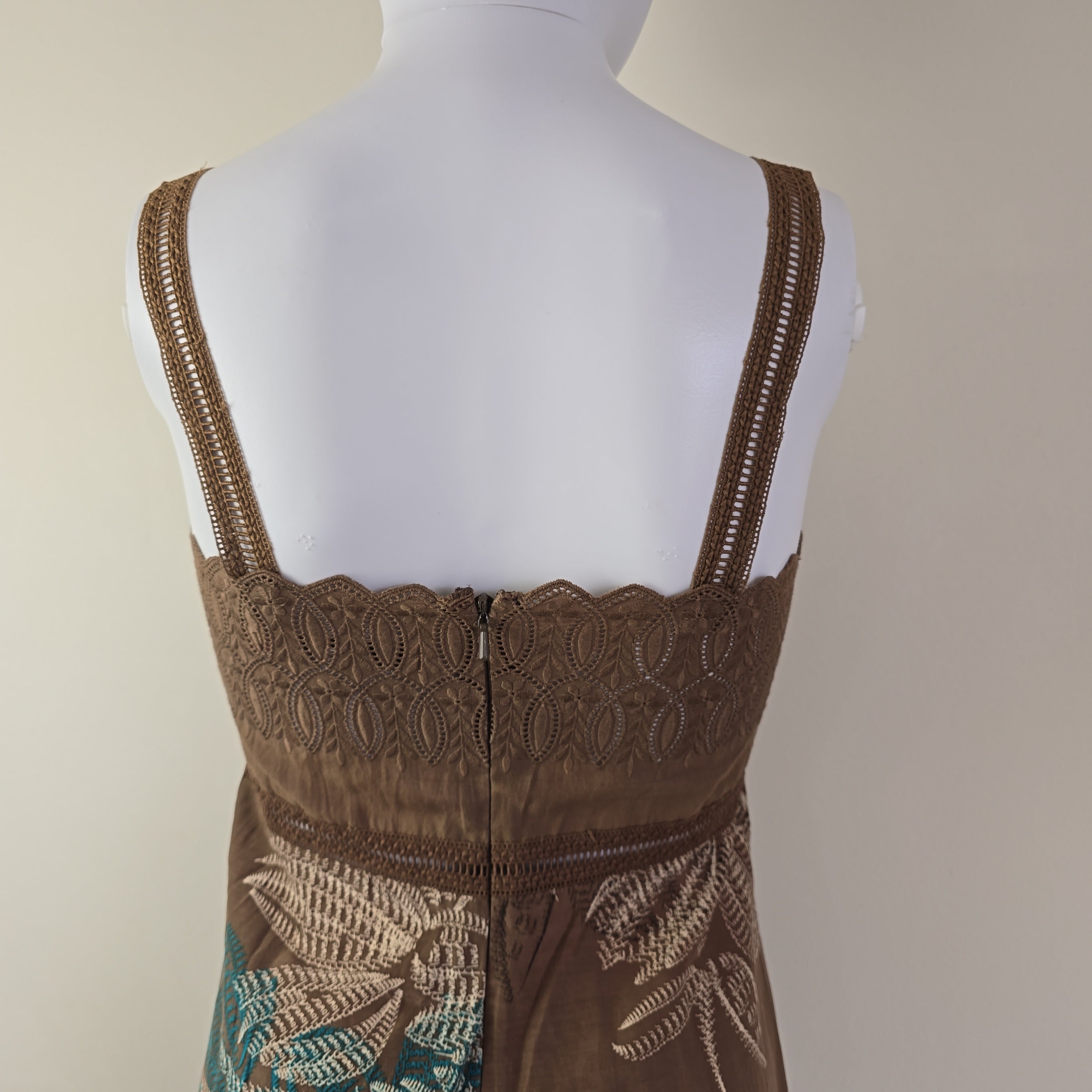 Brown lace dress on a mannequin against a beige background