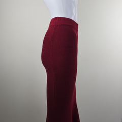 Close-up of a maroon fabric skirt on a white shirt against a neutral background