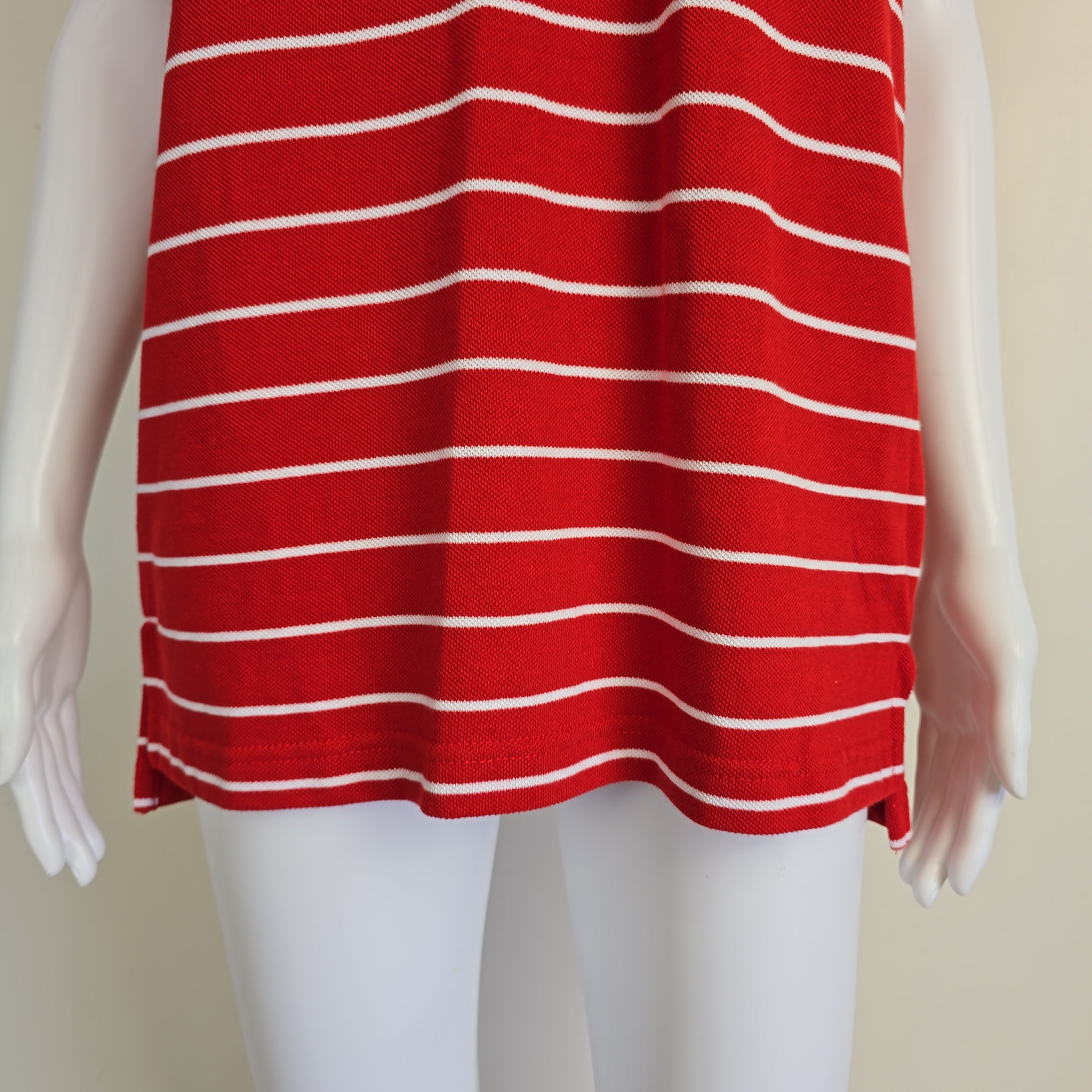 Red and white striped fabric draped over a mannequin arm against a beige background
