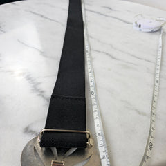 Black belt with a silver buckle on a marble surface