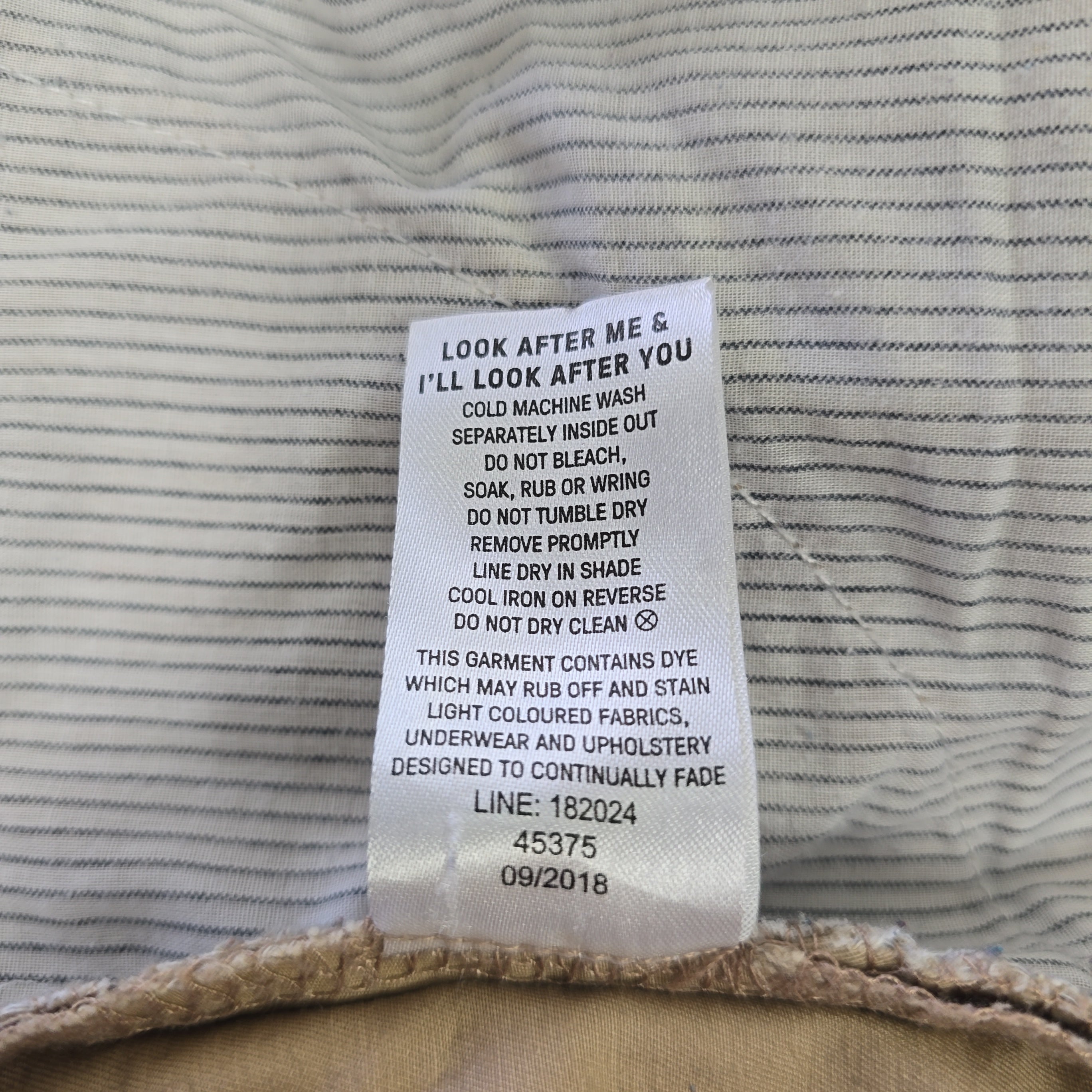 Fabric with a care label on a textured beige background