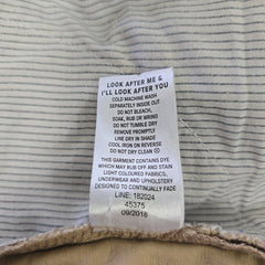 Fabric with a care label on a textured beige background