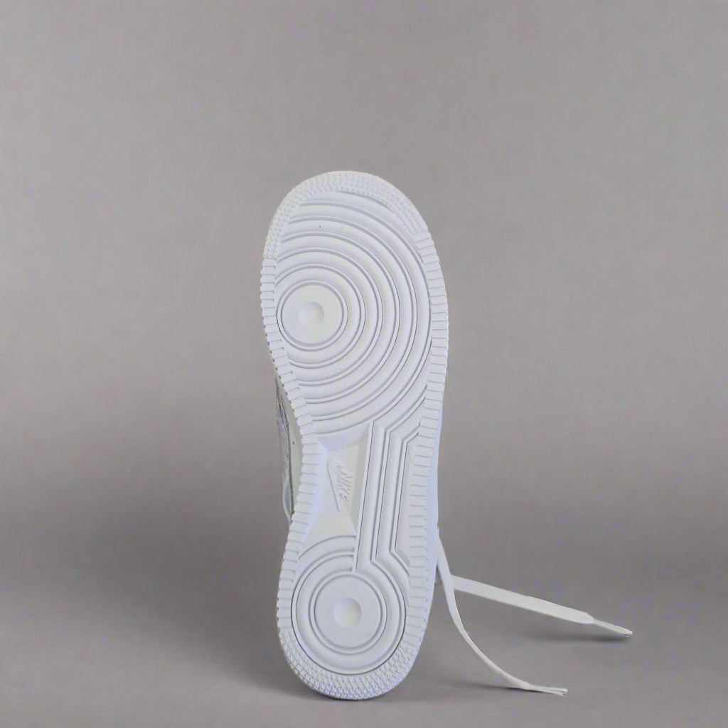 White sneaker with a brand tag on a beige surface