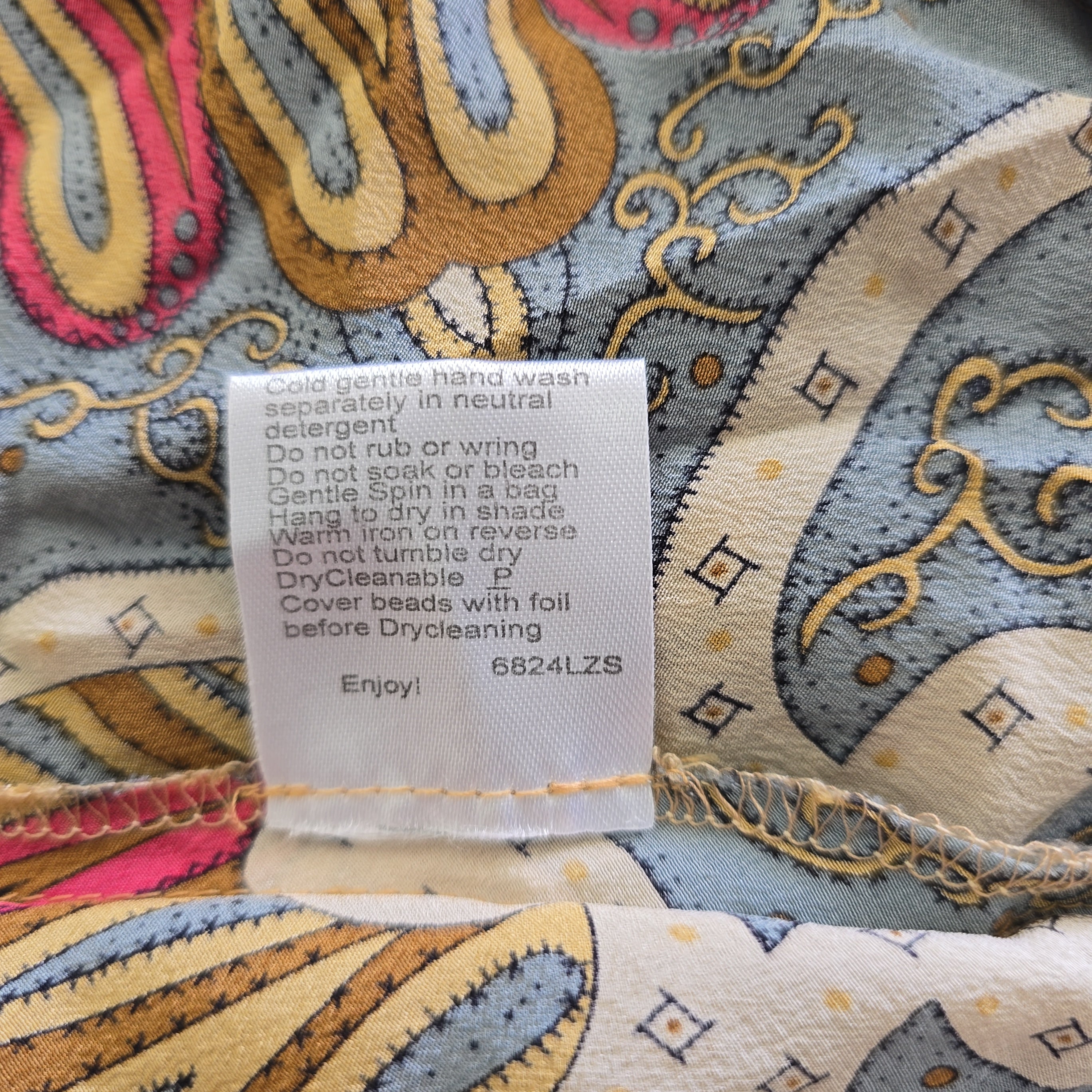 Close-up of a patterned fabric with a care label on a colorful background