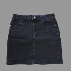 Folded dark grey denim skirt on a tiled floor