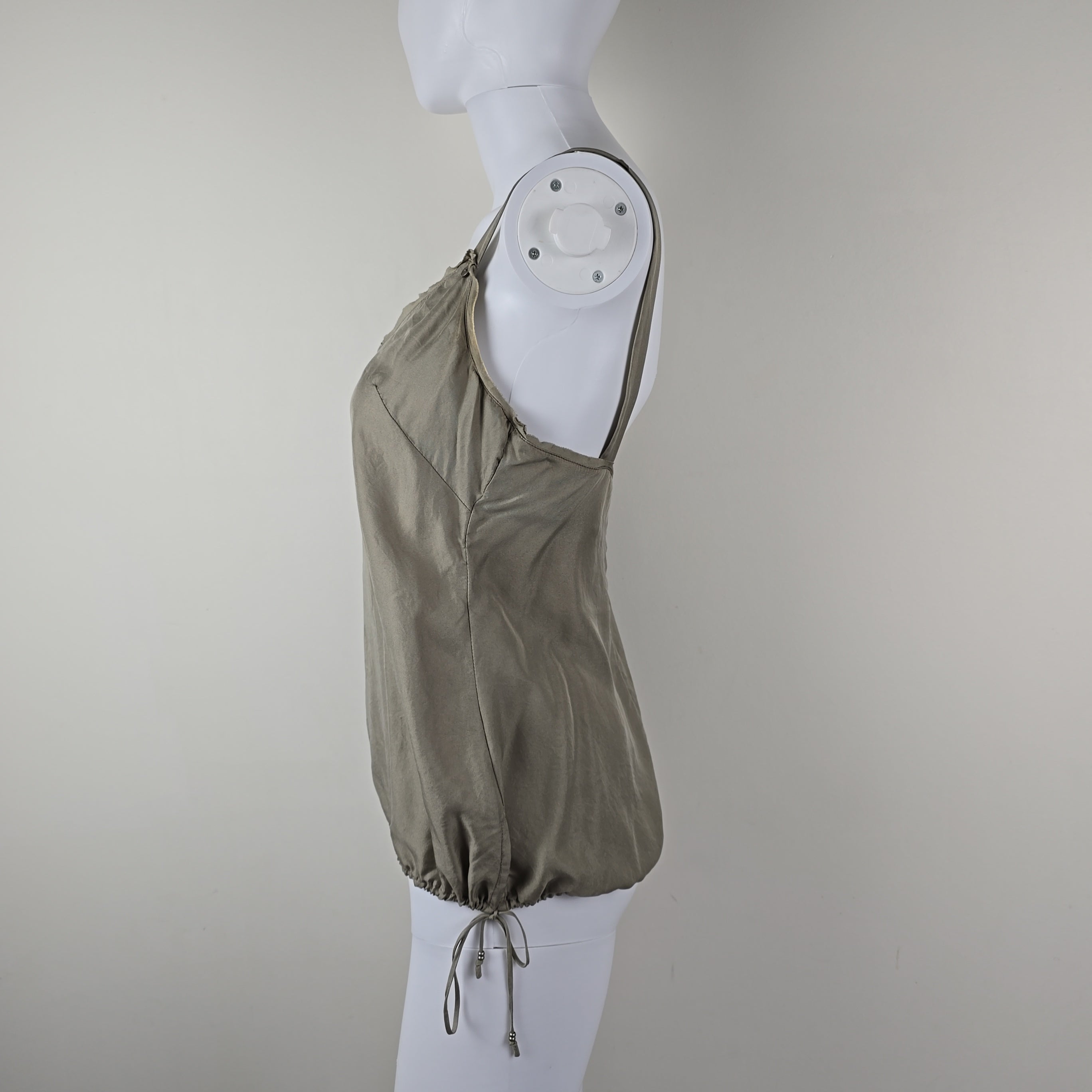 Grey top on a white mannequin against a plain background